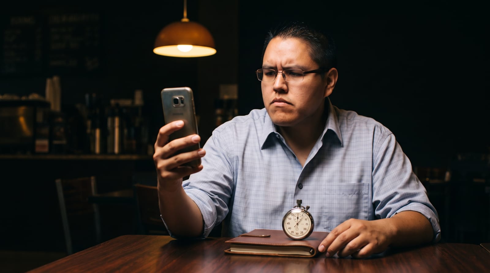 Savelle McThias giving a website on his phone a timed five-second look, stopwatch on the table